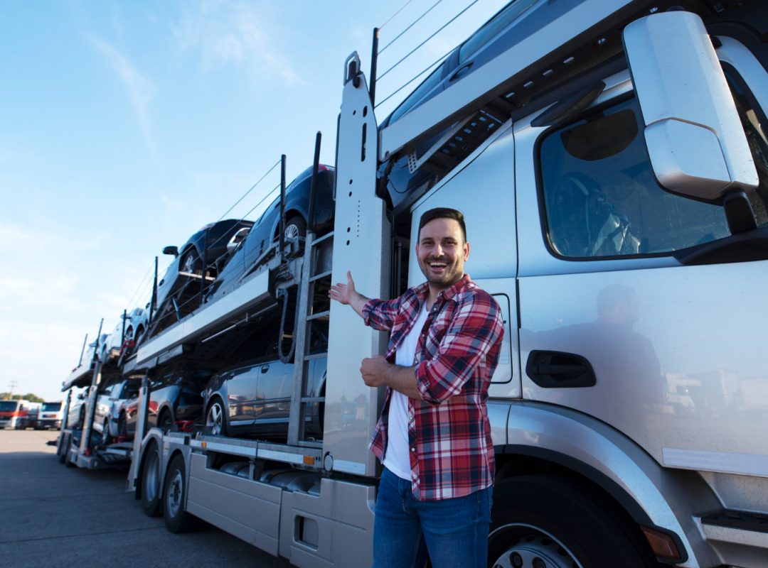 middle-aged-trucker-front-truck-trailer-with-cars middle-aged-trucker-front-truck-trailer-with-cars